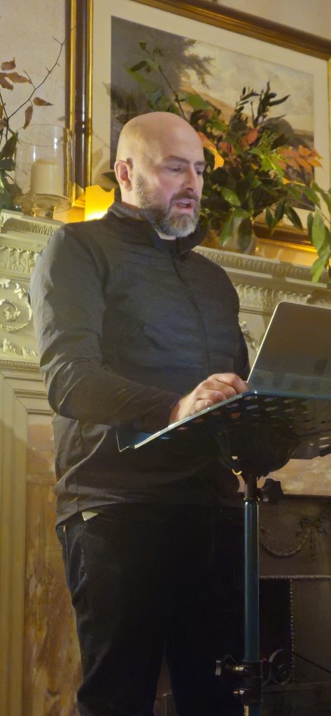 Rob Cowen giving a talk in front of fire at the Devon Writing Retreat